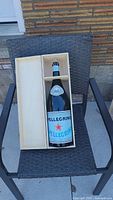 San Pellegrino magnum display bottle resting in a wooden box, showing the bottle label and size.