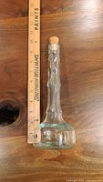 Clear vintage Italian glass bottle with cork stopper shown next to ruler for scale