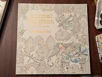 Front cover showing title, author and partially coloured intricate animal and foliage illustrations.