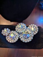 Front view of Jay Kell women's brooch showing five circular blue rhinestone and clear rhinestone clusters arranged in a decorative layout.