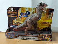 Front side of the Jurassic World Carnotaurus Toro dinosaur figure in its original packaging showing the figure, branding, and talking feature.