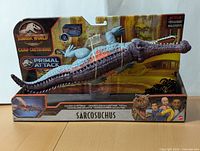 Front view of Jurassic World Camp Cretaceous Primal Attack Sarcosuchus toy in original packaging showing the dinosaur figure and branding.