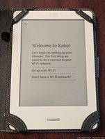 Kobo e-reader powered on to WiFi setup screen, white frame visible, held in Targus case.