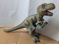 Front view of the large Tyrannosaurus Rex figurine showing textured skin and open mouth.