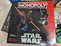 Front cover of Star Wars Dark Side Monopoly board game box showing main characters of the Dark Side faction and Star Wars logo.