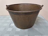 Full side view of a brass antique jelly pot showing the overall shape and size.