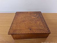 Closed square wooden box with pyrography depicting floral and female profile design, labeled 'Handkerchiefs'.