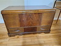 Exterior front view of wooden chest showing wood grain and lockable lid.