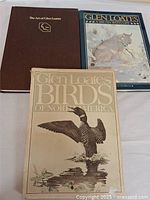 Three Glen Loates art books displayed flat side by side, showing covers