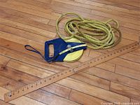 Lot laid out on a wooden floor showing measuring tape, rope, and yard stick