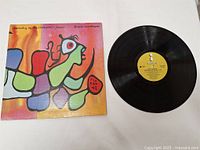 Full view of the album cover and vinyl record of Dancing in the Dragon's Jaws by Bruce Cockburn