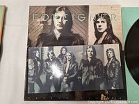 Foreigner Double Vision album cover with two band members on front, in sepia wood-textured background, includes black and white photo insert of band.