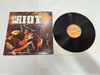 Front view of H.P. Riot vinyl record LP with cover sleeve and the vinyl partially removed.