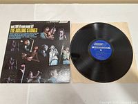 Photo showing vinyl record out of sleeve, with album cover visible on left side.