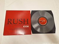 Transparent vinyl LP record with red center label showing 'Rush Icon' text, partially inside a black inner sleeve.