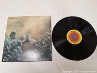 Vinyl LP record with colorful label and original album cover featuring insect image