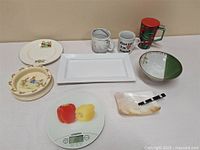 Overview photo showing all kitchen items including the Starfrit kitchen scale, various plates, bowls, mugs, and glass stein.