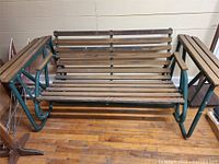 Front view of swinging garden bench showing wooden slats and metal frame.