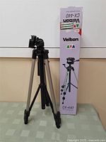 Velbon CX-440 tripod standing next to its original vertical box, showing overall tripod size and packaging.