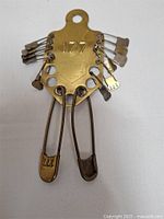 Full view of vintage brass military laundry key rack with central number 177 and attached keys, showing maker's mark by Keyes-Davis Co.
