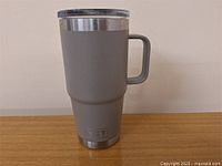 Full view of the grey Yeti travel mug showing handle, lid and overall design