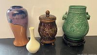 Four ceramic vases arranged side by side showing colors, shapes, and details.