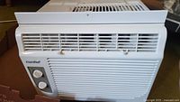 Front view of white Comfee air conditioner with two rotary control knobs and front air vents.