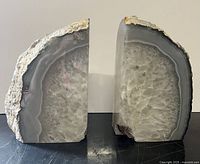 Front view of two solid stone crystal bookends showing polished crystal faces and rough natural stone backsides.