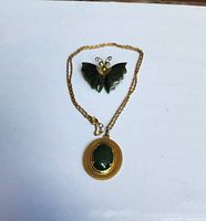 Both brooch and necklace laid flat on white background