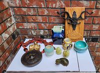 Overall view of all items displayed on table against brick wall background showing size and condition.