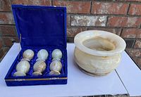 Photo showing 6 onyx goblets arranged in blue velvet-lined case next to a round onyx stone sensor