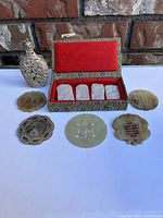 Overview of all jade pendants, discs and metal snuff bottle arranged on surface