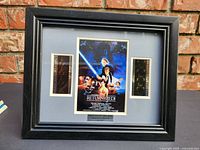 Front view of black wooden frame with film cel windows and Return of the Jedi poster print.