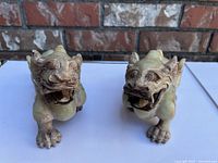 Front view of both statues showing facial details and forward stance