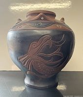 Front view of wooden vase showing carved dragon head and neck details.