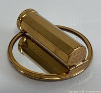Gold tone lipstick case with round mirror partially open, showing minor spotting on mirror surface and octagonal lipstick holder.