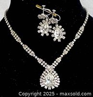 Close-up of necklace and earrings together on display stand showing design and rhinestones