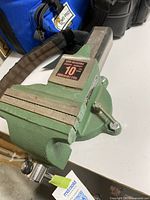 Front and top side view of green General International bench vise showing jaw and label