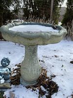 Bird bath shown with snow in the bowl and surrounding area, illustrating size and condition.