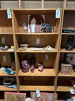 Full front view of the faux light wood tone bookshelf showing five shelves and some contents (not included) placed on it.