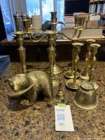 Overview of lot on countertop including candelabra, candlesticks, bear figurine, bowl and bell