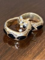 Pair of hoop earrings angled to show black enamel inlays and overall design