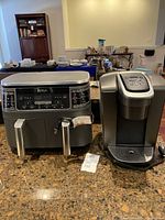 Ninja dual-zone air fryer and Keurig coffee maker side by side on countertop