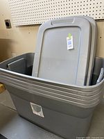 Five stacked gray Sterilite plastic storage totes with lids, showing the side and top of the stacked boxes.