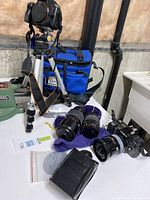 Overview of Sony camera on tripod, Minolta camera, three lenses, Lowepro bag, leather case