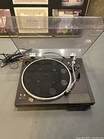 Front view of Sony turntable with dust cover open showing platter and tonearm