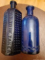 Side view showing embossed text on rectangular bottle and hatch pattern on cylindrical bottle