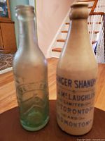 Side view of the two bottles showing different materials and branding