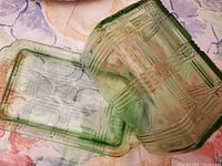 View of green depression glass container and matching lid positioned separately to show design and condition.