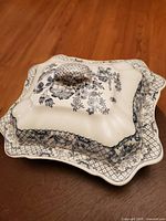 Photo showing the serving piece with lid, highlighting the intricate blue floral and bird pattern, scalloped edges, and lattice border on the dish and lid.